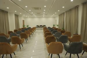 a room with rows of chairs and a table at The City Crown Bilaspur in Bilāspur