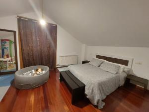 O Alecrin de Bouzas Ribeira Sacra في Pereiro de Aguiar: غرفة نوم فيها سرير وكرسي