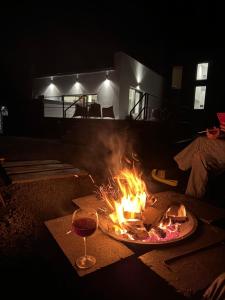 a fire in a living room with a glass of wine at Casa Alma in Piatra Neamţ +66 photos