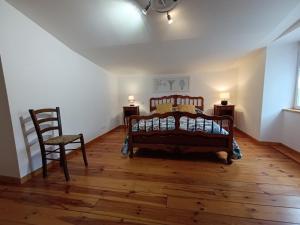 1 dormitorio con 1 cama y 2 sillas en una habitación en Gîtes de la Bibudière en Le Boupère
