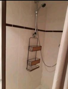 Una ducha con repisa en un baño. en Agréable chambre pour 2 avec salle de bain et terrasse privées, en Fagnières