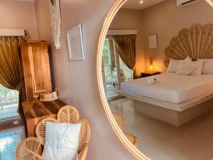 a bedroom with a mirror and a bed and chairs at Follow Your Dreams Gili Air in Gili Islands