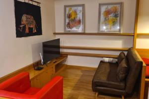 a living room with a couch and a television at Il Nido di legno in Udine