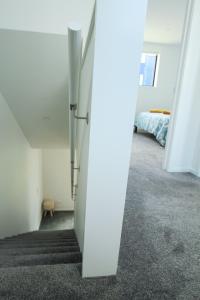 een lege kamer met een gang met een bed bij New and Cosy on Salisbury Street - City Centre in Christchurch
