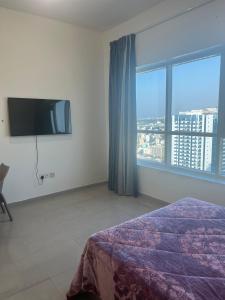 a bedroom with a bed and a flat screen tv at fantastic city & Seaview Master bedroom in 3bedroom apartment in Ajman 