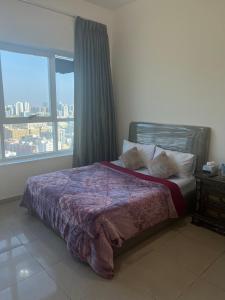 una camera da letto con un letto e una grande finestra di fantastic city & Seaview Master bedroom in 3bedroom apartment ad Ajman