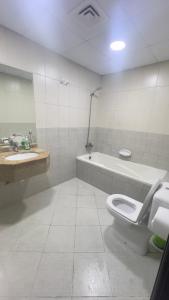 a bathroom with a toilet and a sink and a tub at fantastic city & Seaview Master bedroom in 3bedroom apartment in Ajman 