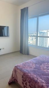 a bedroom with a bed and a large window at fantastic city & Seaview Master bedroom in 3bedroom apartment in Ajman 