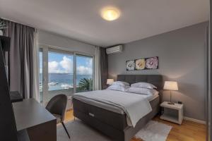 sypialnia z łóżkiem i widokiem na ocean w obiekcie Apartments Sax w Crikvenicy