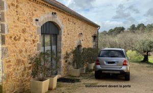 a car parked in front of a stone building at Chambre d'hôtes indépendante de Pouzatel proche Bonaguil in Fumel +12 photos