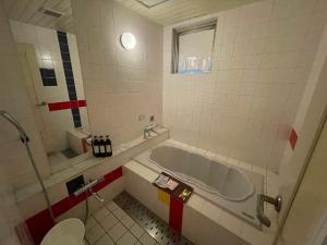 a bathroom with a tub and a toilet at Hotel Luxe - Adult Only in Tokyo