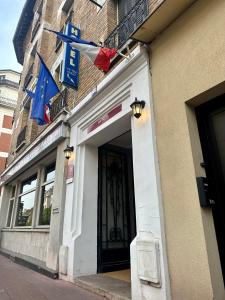 un edificio con banderas a un lado. en Hotel Victor Hugo, en Clamart