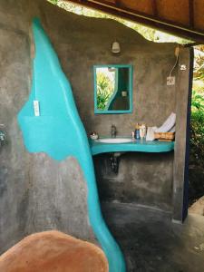 une salle de bains avec un dauphin bleu peint sur le mur. dans l'établissement Pondok Apsari 2, à Singaraja