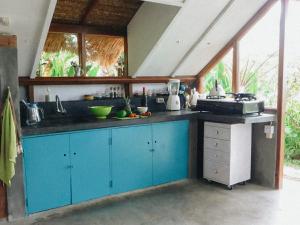 a kitchen with blue cabinets and a sink at Pondok Apsari 2 in Singaraja