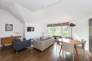 a living room with a couch and a table and chairs at Cool urban apartment with stunning Castle views in Edinburgh