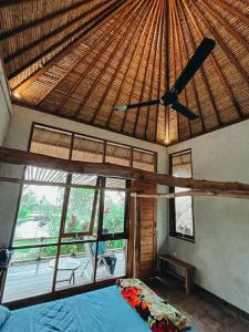 - une chambre avec un ventilateur de plafond et un lit dans l'établissement Pondok Apsari 2, à Singaraja