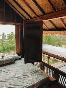 Habitación con cama grande en habitación con ventana en Pondok Apsari 2 en Singaraja