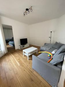 een woonkamer met een bed en een televisie bij Parisian charm flats in Levallois-Perret