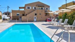 a large swimming pool with chairs and a building at Spiridoula's Apartments Corfu in Perama
