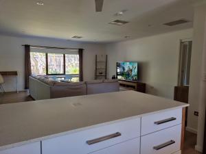 una sala de estar con un sofá y una mesa en Pool to Sand in 800mtrs - Heated Pool and Pet Friendly, en Rye