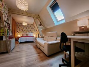 a living room with a couch and a bed at Chez Maméta - Séjour à Auxerre in Auxerre