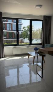 a living room with a table and a large window at Skau Zuckermandel Danube view Free Parking in Bratislava