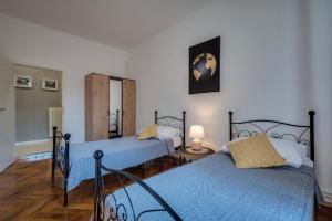 a bedroom with two beds with blue sheets at Apartment Sorelle Fiume in Rijeka