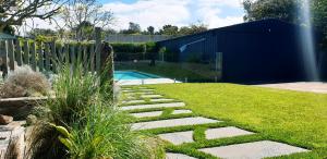 Un jardín con un camino de piedra que conduce a una piscina. en Pool to Sand in 800mtrs - Heated Pool and Pet Friendly, en Rye