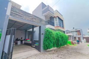 un edificio con un seto verde a su lado en Villa Tera Private Pool and Karaoke, en Tlekung