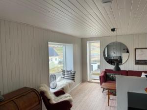 a living room with a red couch and a mirror at STAY-Atlantic in Skálavík