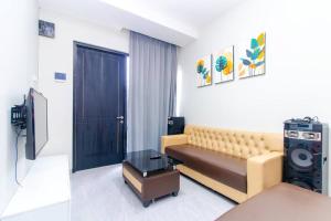 Una sala de estar con un sofá y un televisor en Villa Tera Private Pool and Karaoke, en Tlekung