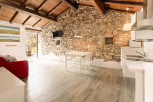 cocina con mesa y pared de piedra en Le Case Nel Borgo, en Fivizzano