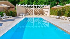 a large blue swimming pool with chairs and umbrellas at Spiridoula's Apartments Corfu in Perama +83 photos