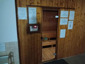 drzwi w pokoju z drewnianą ścianą w obiekcie VIOLA Wellness Apartman w Zalakaros