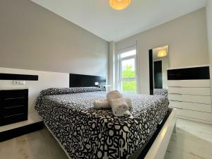 a bedroom with a bed with a black and white comforter at Castelao AP in Santiago de Compostela