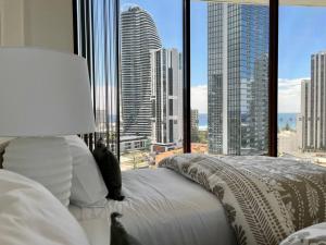 a bedroom with a bed with a view of a city at Private Sky Terrace Classic Penthouse 2 Car Parks in Gold Coast +70 photos