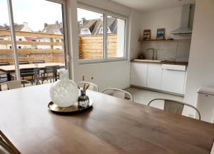 eine Küche mit einem Tisch und einer Vase darauf in der Unterkunft Superbe duplex 50 mètres de la plage in Le Portel