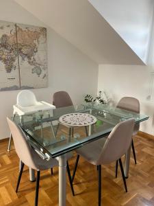 a glass table and chairs in a room with a map at Apartman MIA Centar in Kruševac
