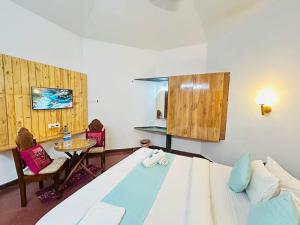 a bedroom with a large bed and a table and chairs at Harbor Court, Vagator in Vagator