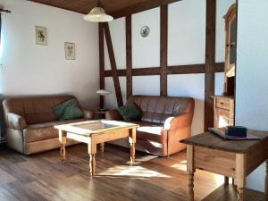uma sala de estar com um sofá e uma mesa de centro em Detached holiday residence in the wonderfully beautiful Harz em Kamschlacken