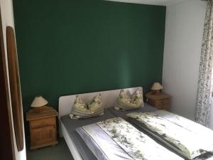 um quarto com uma parede verde e uma cama com almofadas em Detached holiday residence in the wonderfully beautiful Harz em Kamschlacken