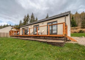 a house with a large deck on the side of it at Shoreland Lodges - Holly Lodge in Fort Augustus