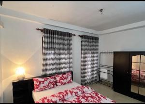 um quarto com uma cama com lençóis vermelhos e uma lareira em Araliya Uyana Apartments - Two Bed Room House em Ratmalana
