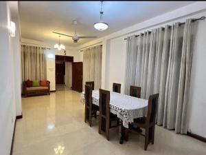 uma sala de jantar com uma mesa e cadeiras num quarto em Araliya Uyana Apartments - Two Bed Room House em Ratmalana