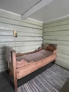 a wooden bed in a corner of a room at Draget gård in Molde