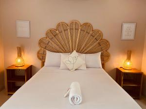 a bed with a wooden headboard with a towel on it at Follow Your Dreams Gili Air in Gili Air