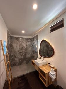 een badkamer met een wastafel en een spiegel aan de muur bij Rock'n Reef in Uluwatu