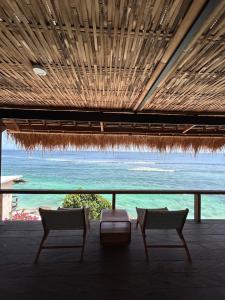 a room with two chairs and a view of the ocean at Rock'n Reef in Uluwatu