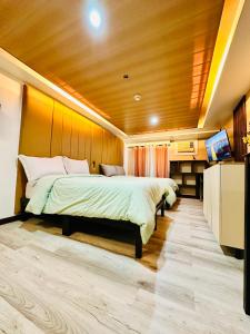 1 dormitorio con 1 cama grande y techo de madera en Feels Like Home Condos Abreeza Place Tower 1 & 2 en Davao