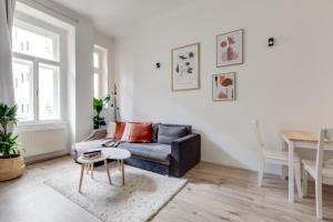 uma sala de estar com um sofá e uma mesa em Romantic apartment by the park - uaka7 em Praga